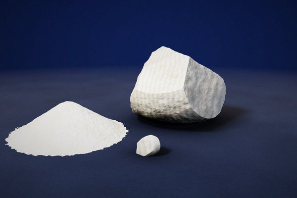 Calcium sulphate: fibrous white gypsum rock and a pile of calcium sulphate powder