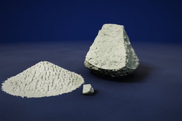 Zeolite: a grey-green porous mineral rock and a pile of zeolite granules